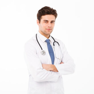 Portrait of a hansome young male doctor with stethoscope dressed in uniform standing with arms folded and looking at camera isolated over white background